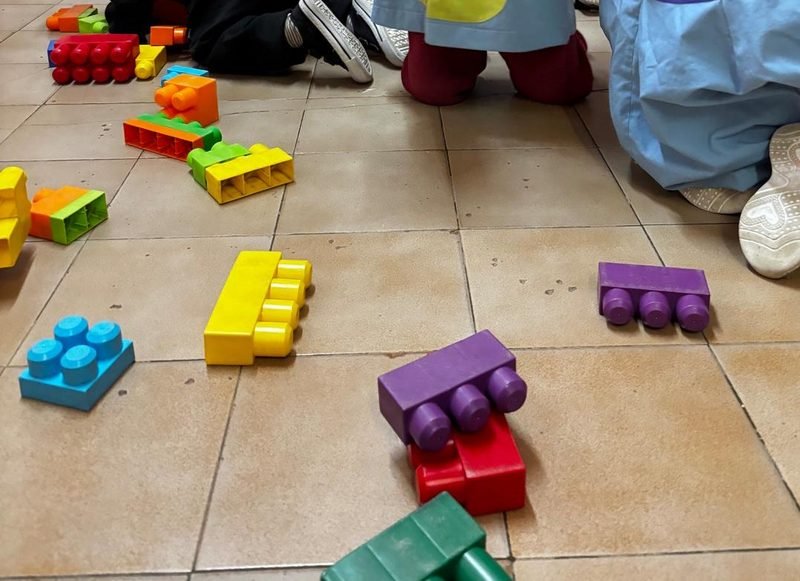 Bloques de encastre grandes y de colores desparramados en el piso de la sala durante el juego